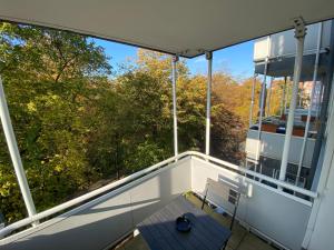 uma varanda com um banco e vista para as árvores em Apartment Hannover /Laatzen em Hanôver
