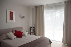 um quarto com uma cama com uma almofada vermelha em Vintage Provence em Arles