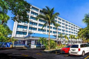 un gran edificio con coches estacionados frente a él en North Miami Beach Gardens Inn & Suites en North Miami