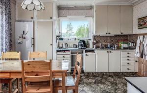 a kitchen with a wooden table and a table and chairs at Beautiful Home In Arvidsjaur With 2 Bedrooms, Sauna And Wifi in Arvidsjaur