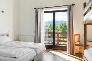 um quarto com 2 camas e uma grande janela em Pensiunea ANA Vistisoara em Vistisoara