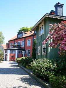 ein grünes Gebäude mit rosa Blumen davor in der Unterkunft Slottshotellet in Kalmar