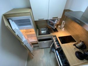 y vistas a una pequeña cocina con nevera abierta. en Apartment Hannover /Laatzen en Hannover