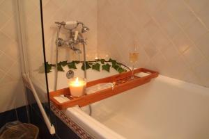 a candle sitting on a wooden shelf in a bath tub at Casa Rural El Tenado in Aldea de Trujillo