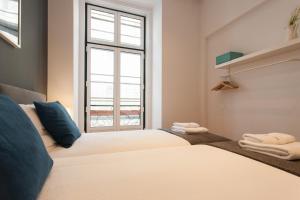 a bedroom with a large white bed with a window at FLH Luxus Baixa Flat in Lisbon
