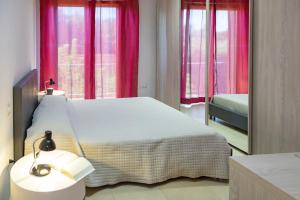 a bedroom with a bed with pink curtains and a mirror at Casa e Mare in Montignano