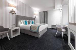 a hotel room with a bed and two chairs at Hotel Juliani - Boutique Hotel in St. Julianʼs