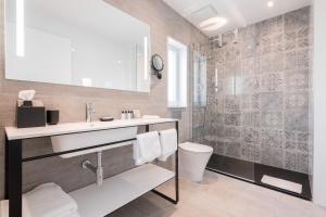 a bathroom with a sink and a toilet and a shower at Hotel Juliani - Boutique Hotel in St. Julianʼs