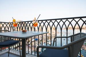 a table and chairs on a balcony with a view at Hotel Juliani - Boutique Hotel in St. Julianʼs