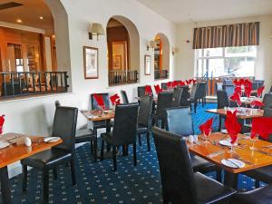 a restaurant with tables and chairs with red napkins at Carrington House Hotel in Bournemouth