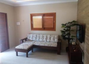 a living room with a couch and a plant at Maragogi Chalé Antunes in Maragogi