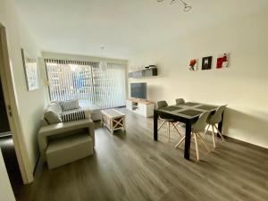 a living room with a dining room table and a couch at Crystal residence - Pool & Beach in Ostend