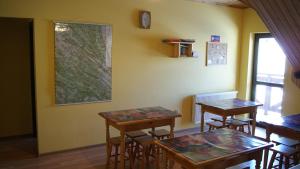 two tables and chairs in a room with yellow walls at Pokoje Gościnne Dorota Andreasik in Wetlina