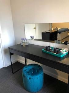 a black desk with a mirror and a blue stool at The Half Moon Inn in Ashington