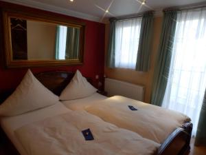 Schlafzimmer mit einem weißen Bett, einem Spiegel und Fenstern in der Unterkunft Hotelschiff Perle Bremen in Bremen
