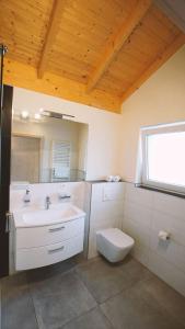 a bathroom with a sink and a toilet and a mirror at Landgasthof Scherer in Wenden