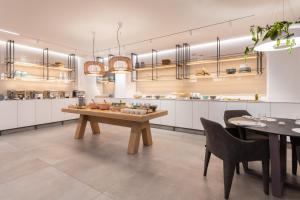 a large kitchen with a wooden table and chairs at Hotel Juliani - Boutique Hotel in St. Julianʼs