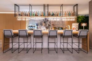 a bar with stools at a counter in a room at Hotel Juliani - Boutique Hotel in St. Julianʼs