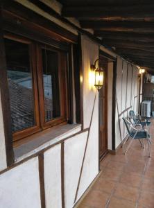 La Herrera lll في San Esteban de la Sierra: شرفة منزل مع نافذة وطاولة