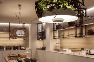 a kitchen with a large pendant light and plants at Hotel Juliani - Boutique Hotel in St. Julianʼs