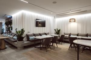 a restaurant with tables and chairs and a tv on the wall at Hotel Juliani - Boutique Hotel in St. Julianʼs