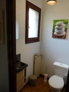 a bathroom with a toilet and a window and towels at LES CHAMBRES DU GAVE D'OSSAU in Arudy