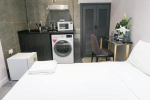 a kitchen with a washing machine and a microwave at Deluxe Studio & Suite by RR in Singapore