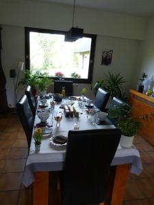 LES CHAMBRES DU GAVE D'OSSAU في Arudy: طاولة طعام مع طاولة قماش بيضاء