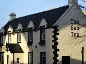 un edificio blanco con la posada solar escrita en él en The Sun Inn en Dalkeith