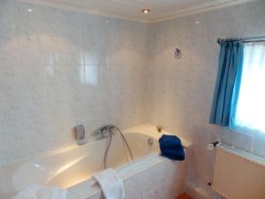 a bathroom with a tub with a blue shower curtain at Hotelschiff Perle Bremen in Bremen