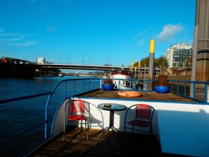 einen Tisch und zwei Stühle auf einem Boot auf dem Wasser in der Unterkunft Hotelschiff Perle Bremen in Bremen