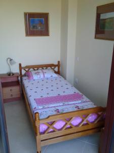 a bedroom with a wooden bed in a room at Avia, house with privillaged view, 100 meters from the sea in Avia