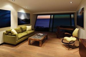 sala de estar con sofá verde y mesa en Playa Vik Jose Ignacio, en José Ignacio