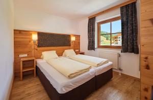 una camera da letto con un letto e una finestra di Aparthotel Lieblingsplatz a Filzmoos