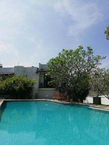 a large blue swimming pool in front of a house at Oak Residencies in Kiribathgoda