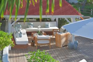 un patio con sillas, mesa y cenador en Les Ilets De La Plage, en Gustavia