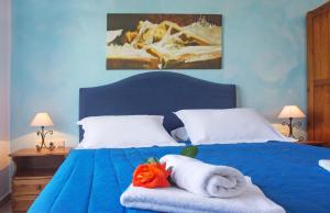 a bedroom with a blue bed with towels on it at Pantonia Apartments in Agia Pelagia