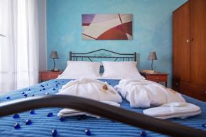 a bedroom with a blue bed with towels on it at Pantonia Apartments in Agia Pelagia