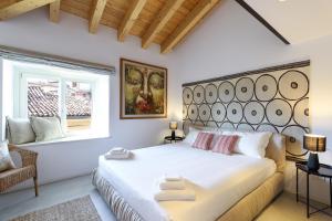 une chambre avec un grand lit blanc et une fenêtre dans l'établissement Altana Bergamo Home, à Bergame