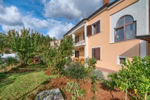 a house with a garden in front of it at Apartments Vera Savic in Poreč
