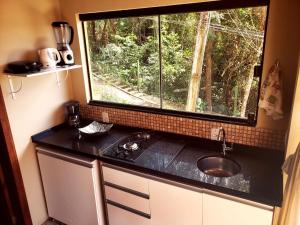 a kitchen with a sink and a window at Plumeria Guest House in Florianópolis