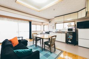 ein Wohnzimmer mit einem Tisch und einer Küche in der Unterkunft Furano - House / Vacation STAY 56483 in Furano