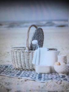 una cesta sentada en una toalla en la playa en Ebeltoft, en Ebeltoft