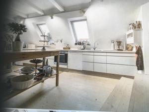 a kitchen with white cabinets and a wooden counter top at Ebeltoft in Ebeltoft
