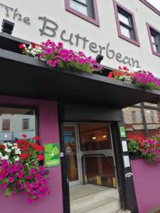 um edifício com flores ao lado em The butterbean accomodation em Carndonagh