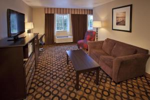 Red Lion Inn & Suites Kent - Seattle Area في كينت: غرفة معيشة بها أريكة وتلفزيون