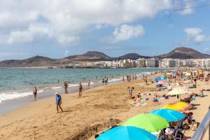 a crowd of people on a beach with umbrellas at Flatguest Luis Morote + Central + Beach + WiFi in Las Palmas de Gran Canaria