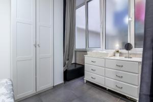 a bedroom with white cabinets and a dresser with a mirror at Flatguest Luis Morote + Central + Beach + WiFi in Las Palmas de Gran Canaria