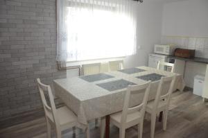 a kitchen with a table and chairs and a window at Dom U Kuby in Hoczew