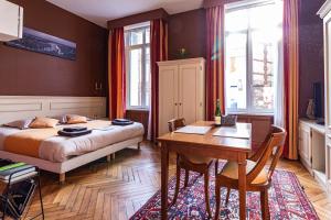 a bedroom with a bed and a desk and a table at La Villa in Rouen